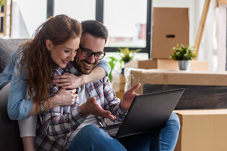 Happy Couple Looking at a Laptop Computer